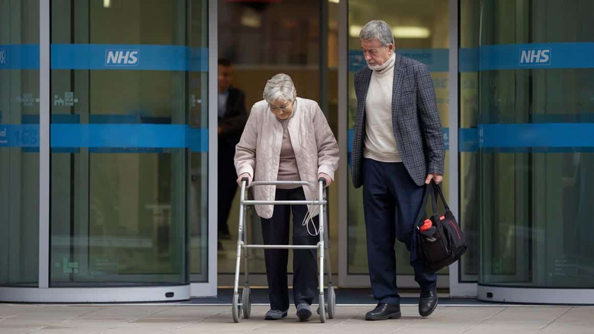 Elderly woman and her son returning home from hospital to receive reablement care